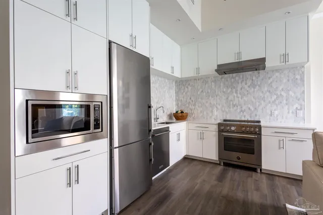 a kitchen with stainless steel appliances and wooden floor