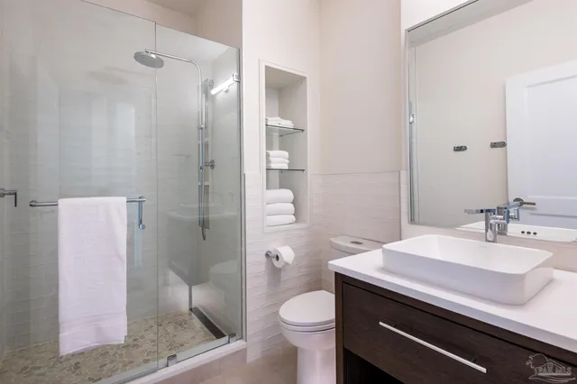 a bathroom with a sink a toilet a shower and a mirror