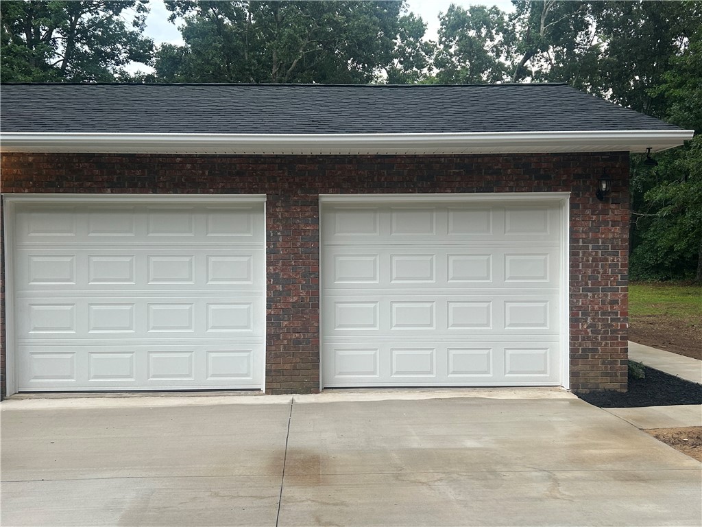 809 Paige Road Honea Path, SC 29654 - Photo 3 of 27 A well-maintained brick garage offers ample space for vehicles, complemented by a new concrete driveway.