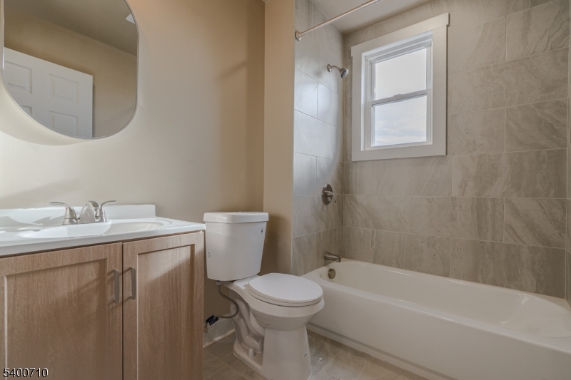 882 South 14th Street, Unit 1 Newark, NJ 07108 - Photo 15 of 17 a bathroom with a toilet a sink a mirror and bathtub