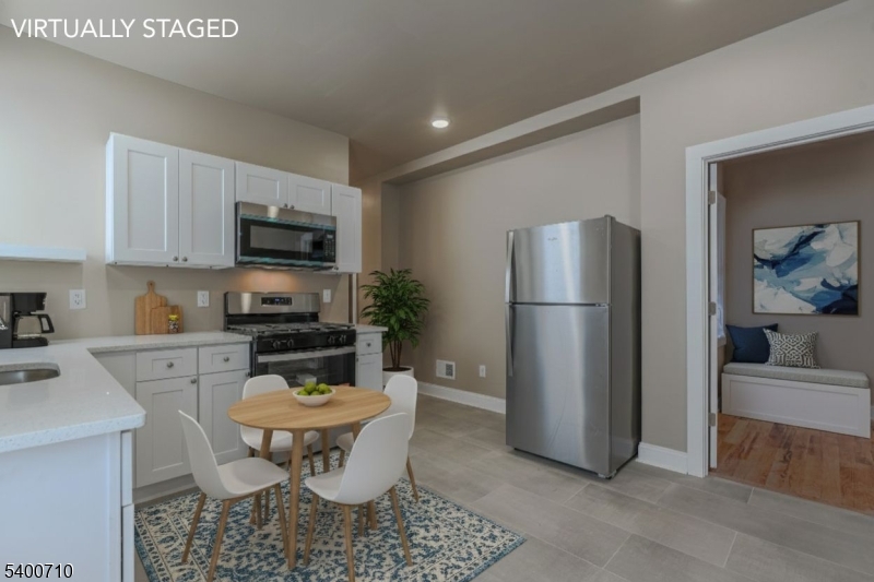 882 South 14th Street, Unit 1 Newark, NJ 07108 - Photo 7 of 17 a kitchen with a refrigerator a stove a microwave and cabinets