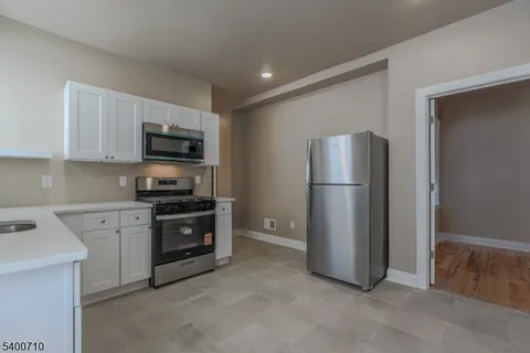 a kitchen with stainless steel appliances granite countertop a refrigerator stove a sink and dishwasher