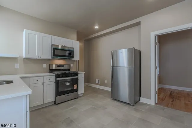 a kitchen with stainless steel appliances granite countertop a refrigerator stove a sink and dishwasher