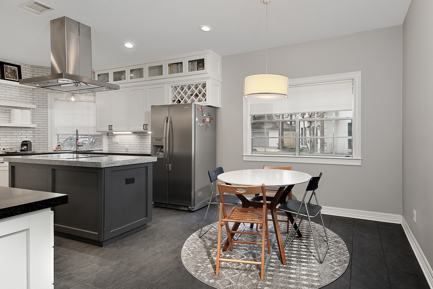 5 Indian Cedar Lane The Woodlands, TX 77380 - Photo 10 of 26 a kitchen with stainless steel appliances granite countertop a table chairs and a refrigerator