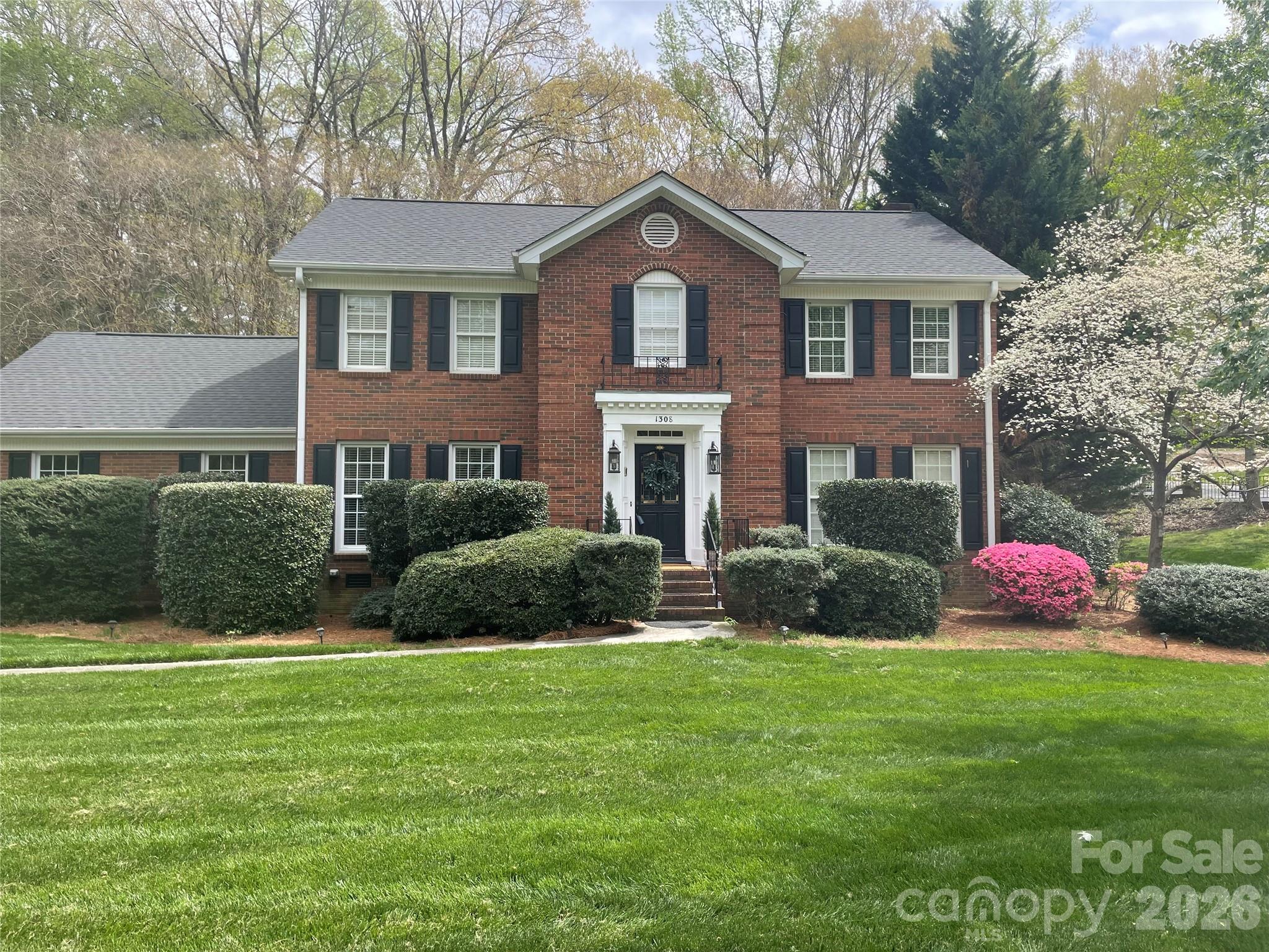 a front view of a house with a yard and trees