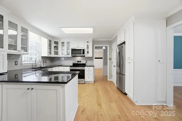 a kitchen with stainless steel appliances granite countertop a stove a sink and a refrigerator