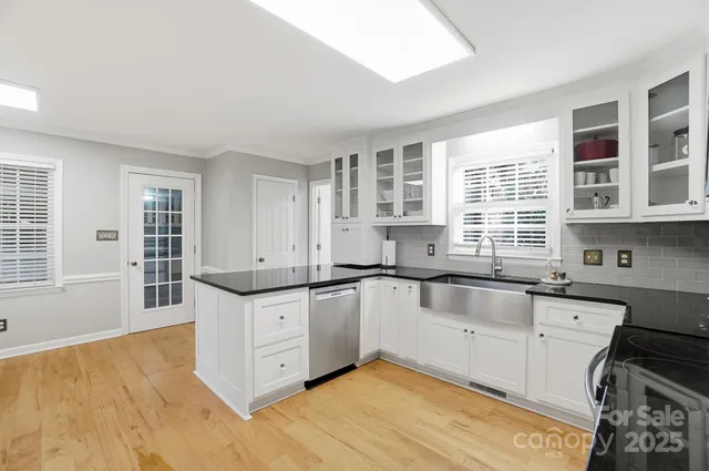 a large kitchen with granite countertop a sink and cabinets
