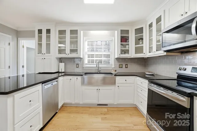 a kitchen with stainless steel appliances granite countertop a sink stove and cabinets