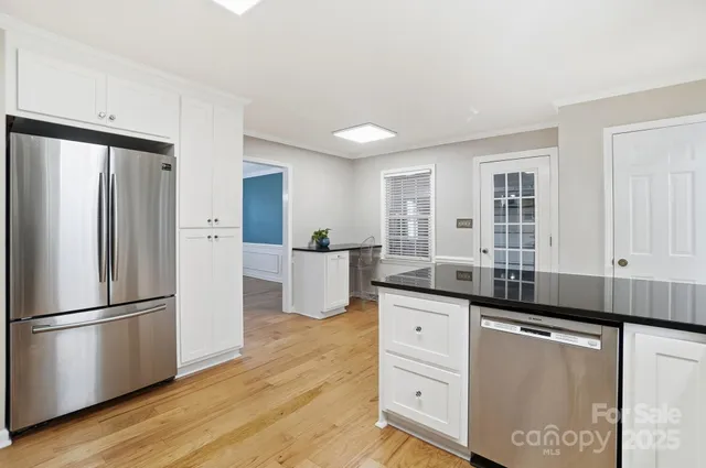 a kitchen with granite countertop a refrigerator sink and cabinets