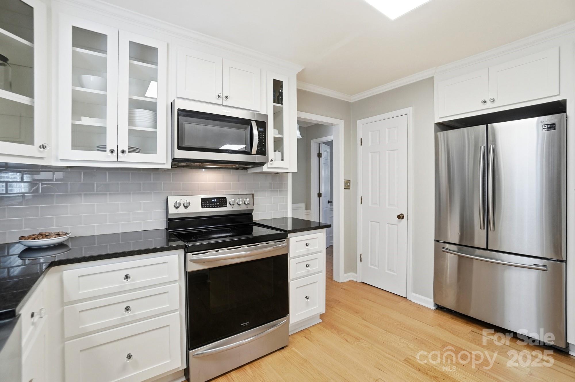 1308 Dumbarton Road Gastonia, NC 28054 - Photo 20 of 48 a kitchen with stainless steel appliances white cabinets and wooden floor