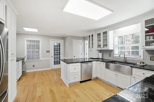 a large kitchen with granite countertop a sink and cabinets