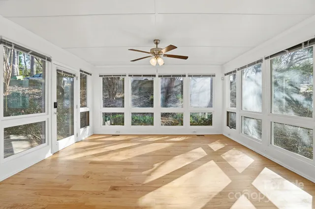 a view of an empty room with a window and a fireplace