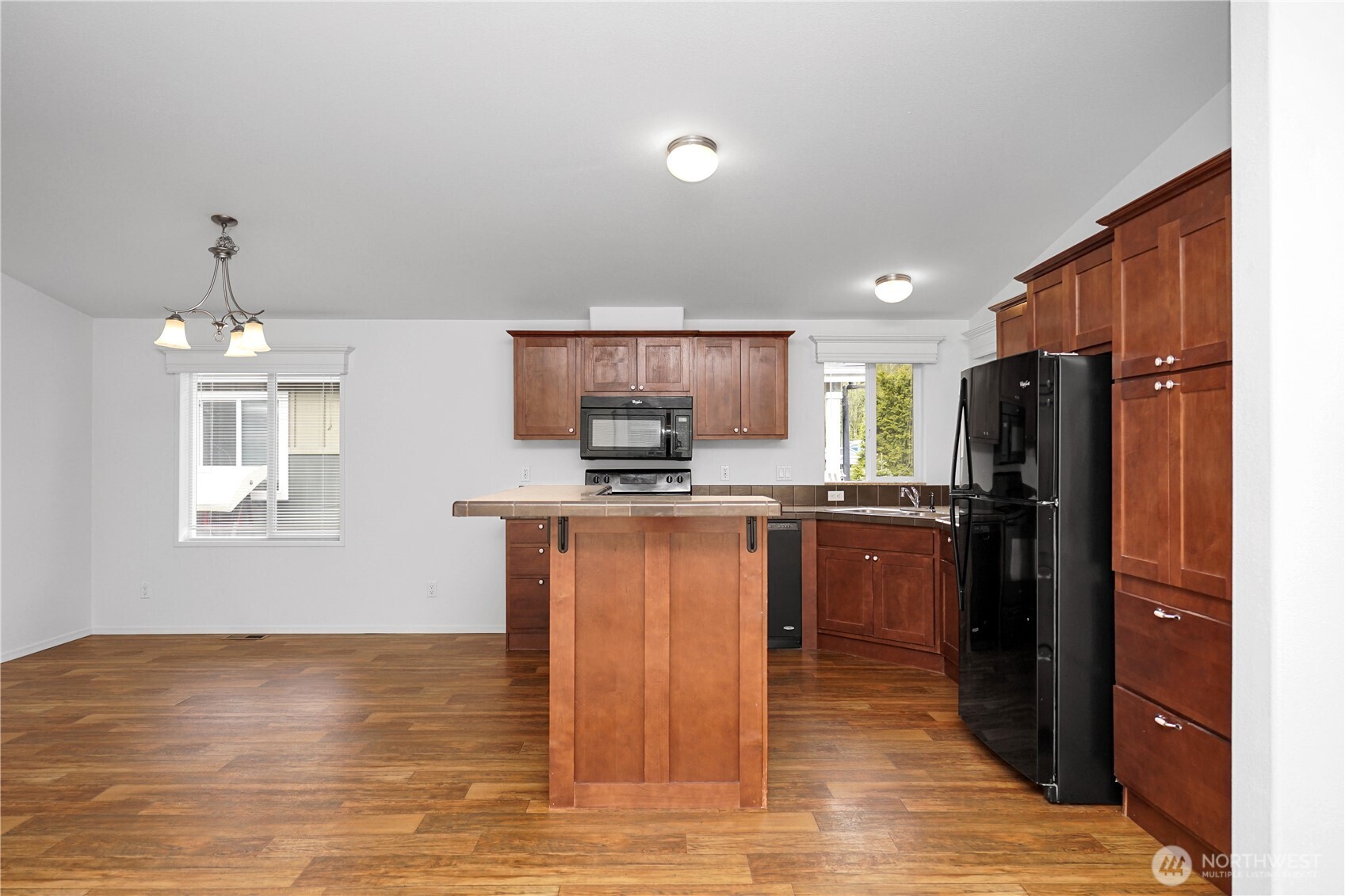 15231 Pine Drive Renton, WA 98058 - Photo 6 of 29 a kitchen with kitchen island granite countertop a refrigerator stove top oven and sink