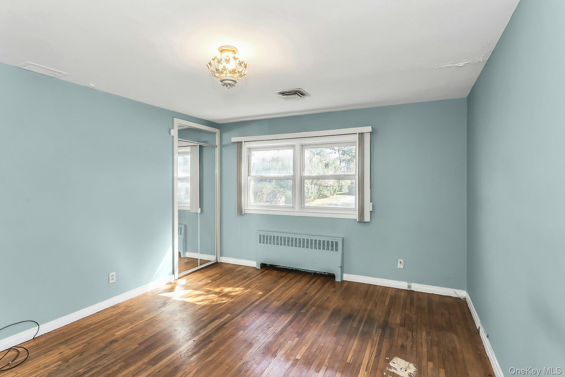 11 Rockhill Road East Hills, NY 11577 - Photo 17 of 27 an empty room with wooden floor and windows