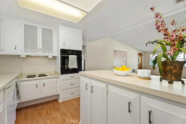 a kitchen with granite countertop white cabinets and white appliances