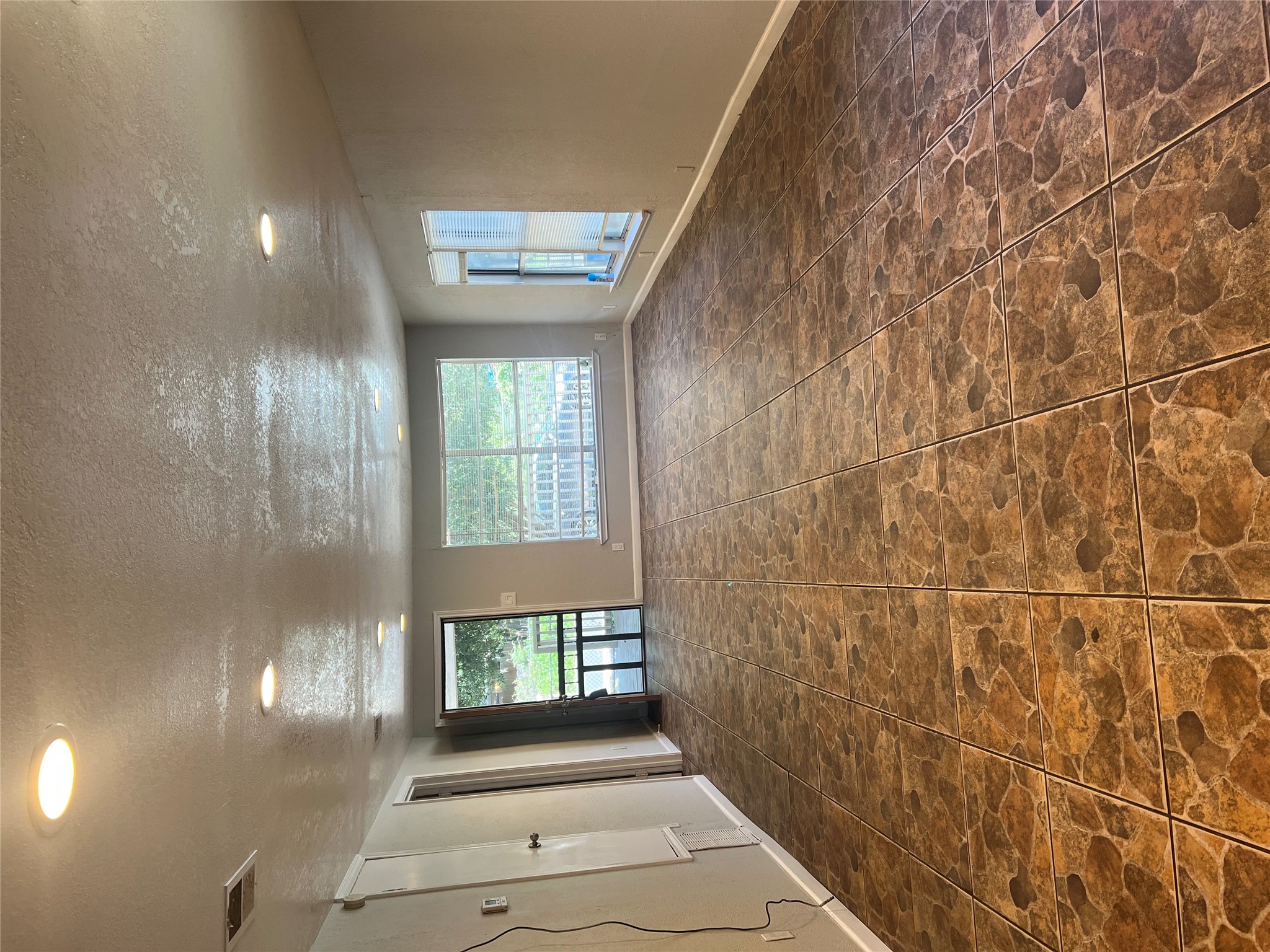 6405 Torres Street Austin, TX 78741 - Photo 2 of 14 A spacious living area awaits, illuminated by recessed lighting and featuring durable tile flooring.