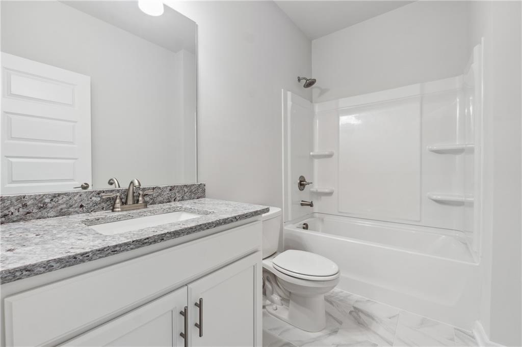 2546 Harbor Ridge Pass, Unit 341 Gainesville, GA 30507 - Photo 18 of 41 a bathroom with a granite countertop sink toilet vanity mirror bathtub and shower