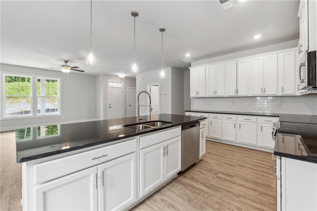 2546 Harbor Ridge Pass, Unit 341 Gainesville, GA 30507 - Photo 6 of 41 a kitchen with stainless steel appliances granite countertop a sink a stove and a wooden floors