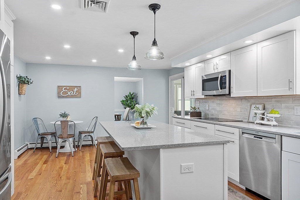 7 Gavin Circle Andover, MA 01810 - Photo 12 of 42 a kitchen with stainless steel appliances granite countertop a stove top oven a sink dishwasher a dining table and chairs with wooden floor