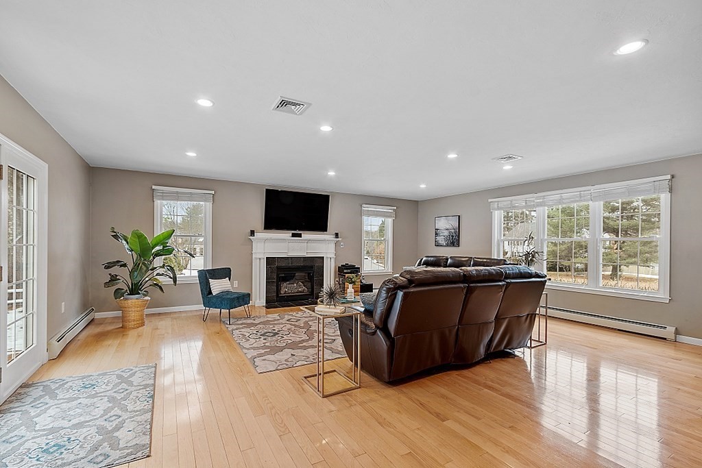 7 Gavin Circle Andover, MA 01810 - Photo 16 of 42 a living room with furniture a fireplace and a flat screen tv