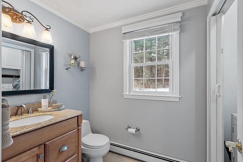 7 Gavin Circle Andover, MA 01810 - Photo 19 of 42 a bathroom with a granite countertop toilet a sink a mirror and a window