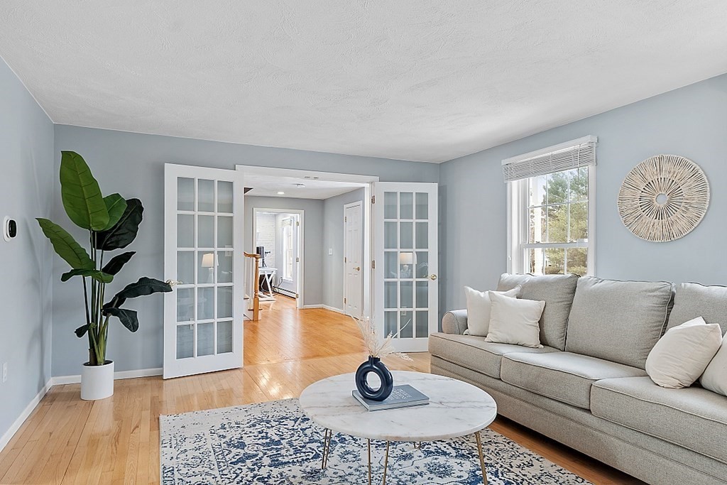 7 Gavin Circle Andover, MA 01810 - Photo 6 of 42 a living room with furniture a wooden floor and a large window