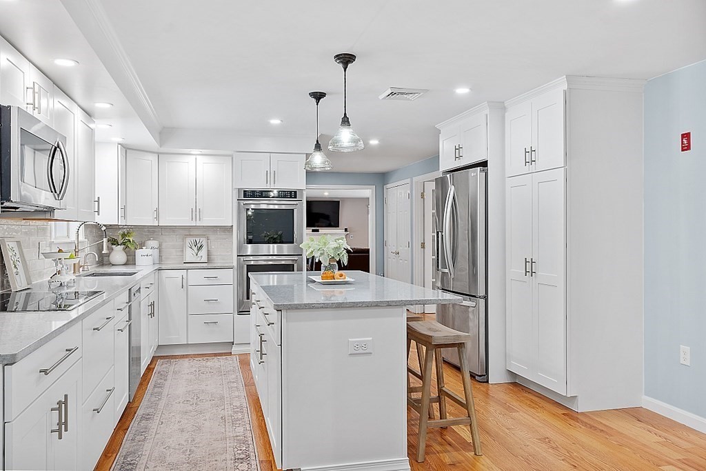 7 Gavin Circle Andover, MA 01810 - Photo 9 of 42 a kitchen with white cabinets and stainless steel appliances