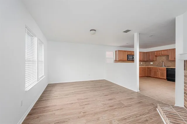 a view of a kitchen with an empty room and window