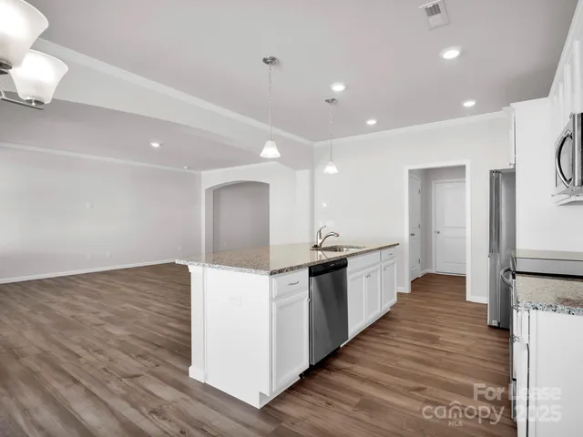 a large kitchen with granite countertop a large counter top and sink