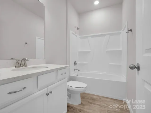 a bathroom with a toilet a sink a mirror and shower