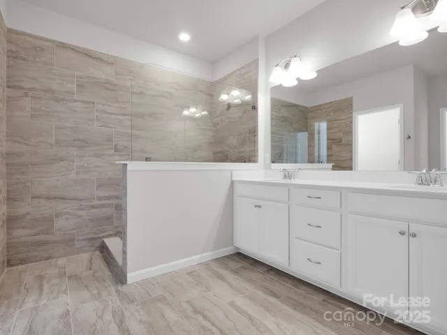 a spacious bathroom with a granite countertop sink a mirror and a