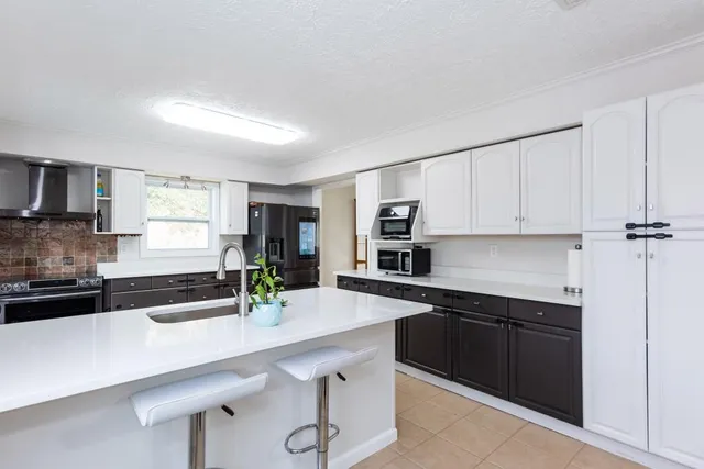 a kitchen with a sink a stove and cabinets