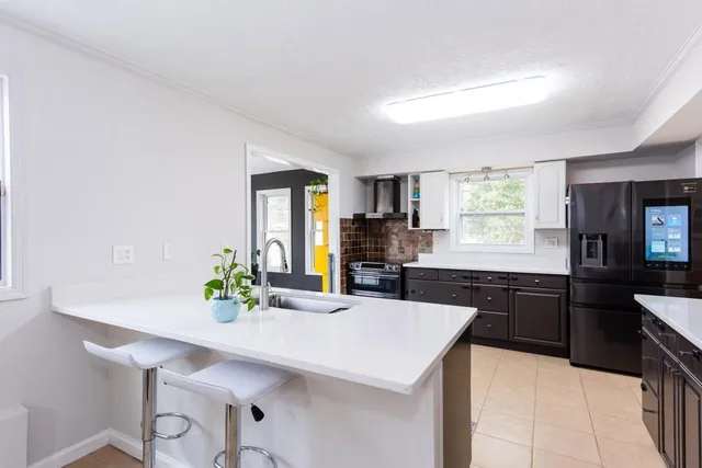 a kitchen with stainless steel appliances kitchen island granite countertop a refrigerator and cabinets