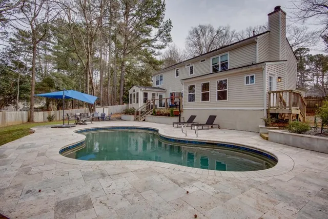 a view of a house with swimming pool and sitting area