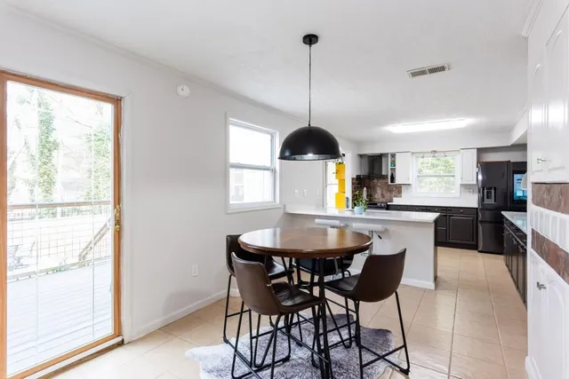 a view of a dining room and livingroom with furniture wooden floor a chandelier