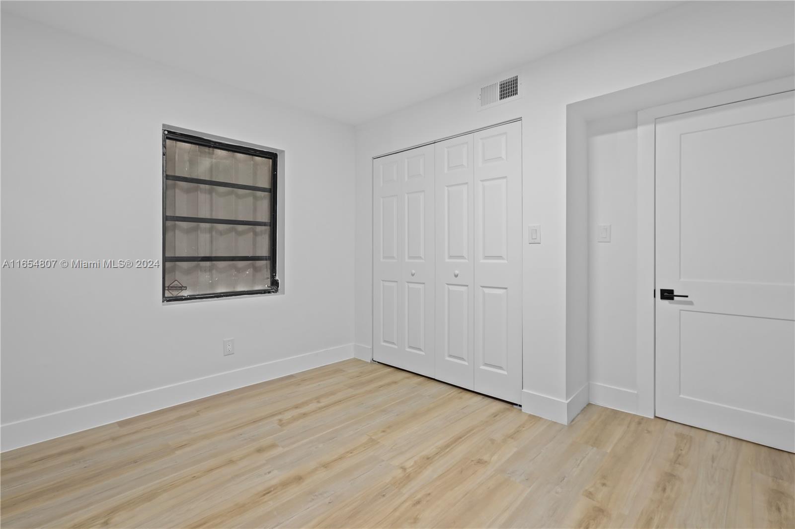 29010 Louisiana Road Homestead, FL 33033 - Photo 9 of 16 a view of an empty room with wooden floor and closet