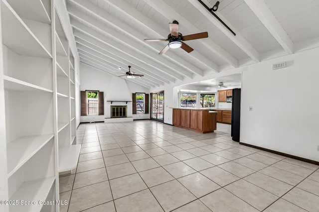 an empty room with window and ceiling fan