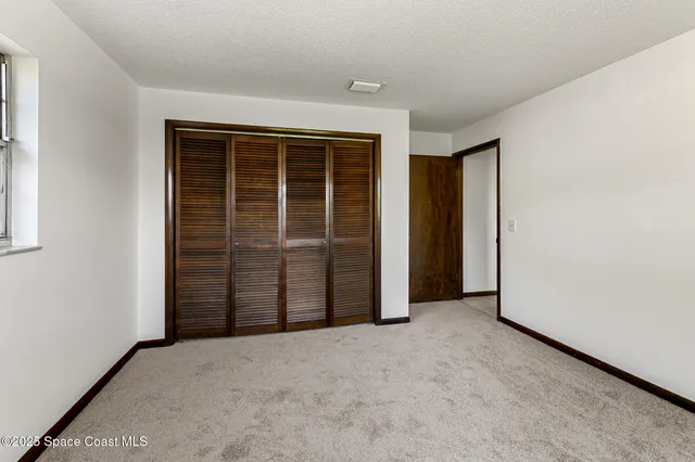 a view of a room with wooden floor and windows