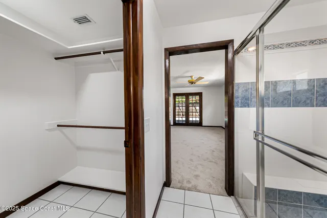 a white house with a big yard and large trees