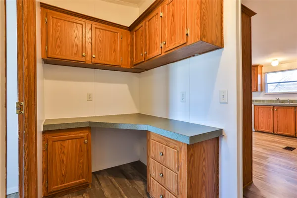 a kitchen with granite countertop cabinets appliances and a wooden floor