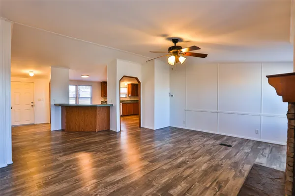 a view of a kitchen with wooden floor and a ceiling fan