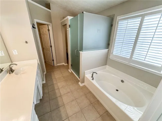 a spacious bathroom with a double vanity sink a mirror and a bathtub