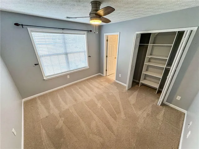 a view of a hallway to a livingroom with wooden floor and staircase