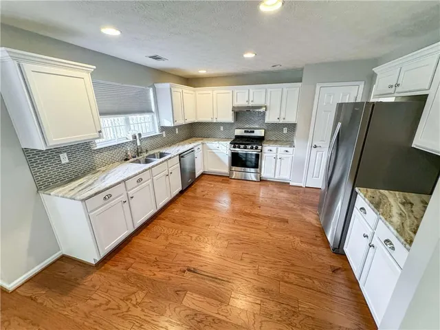 a large white kitchen with cabinets