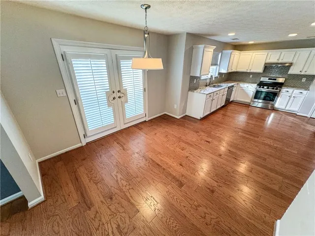 a view of a kitchen with furniture and wooden floor