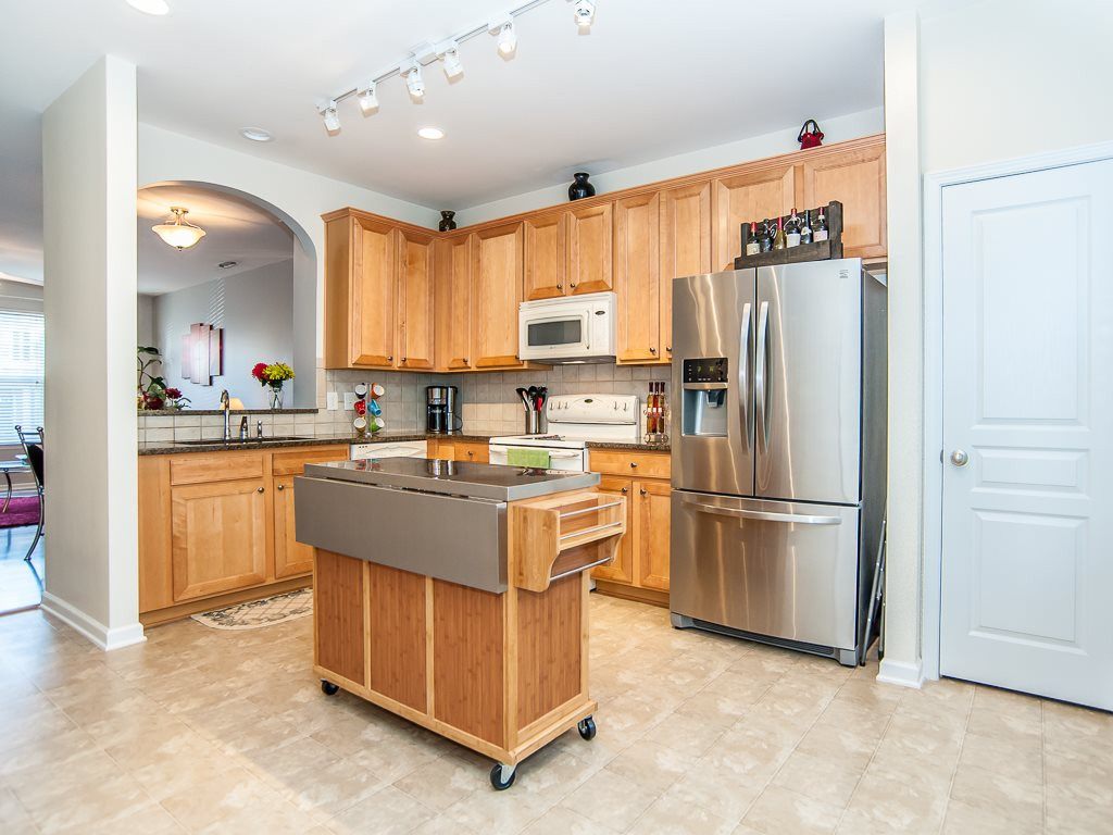 4815 Sir Duncan Way Raleigh, NC 27612 - Photo 14 of 25 Granite countertops and an upgraded Stainless Steel Refrigerator that conveys with the property. Kitchen