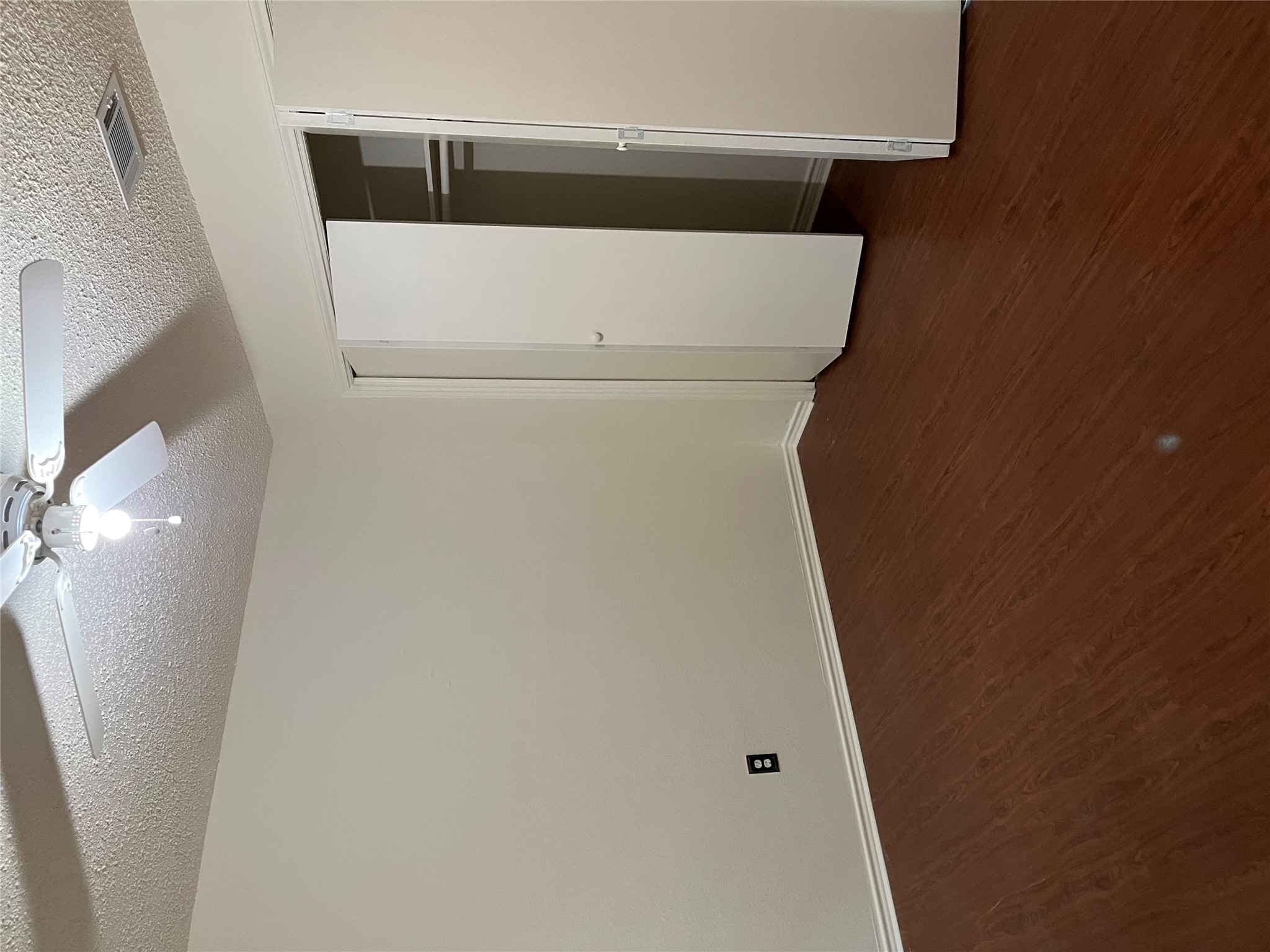 23393 Nameless Road, Unit 144 Leander, TX 78641 - Photo 17 of 23 Unfurnished bedroom featuring dark wood finished floors, baseboards, visible vents, and a textured ceiling