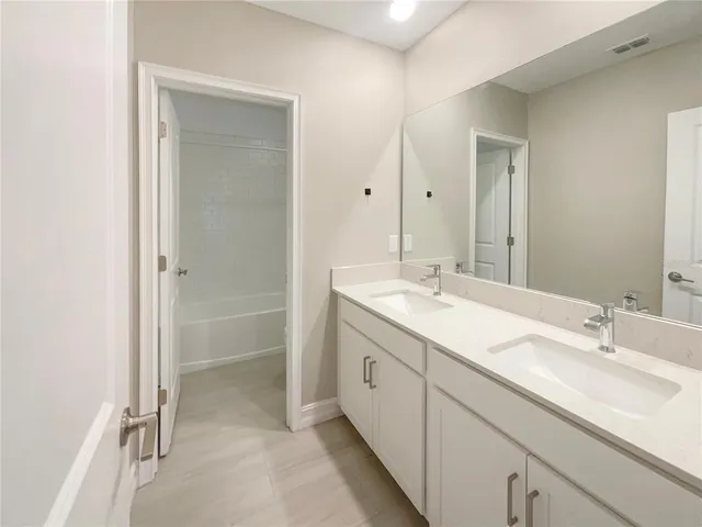 a bathroom with double sink and a mirror