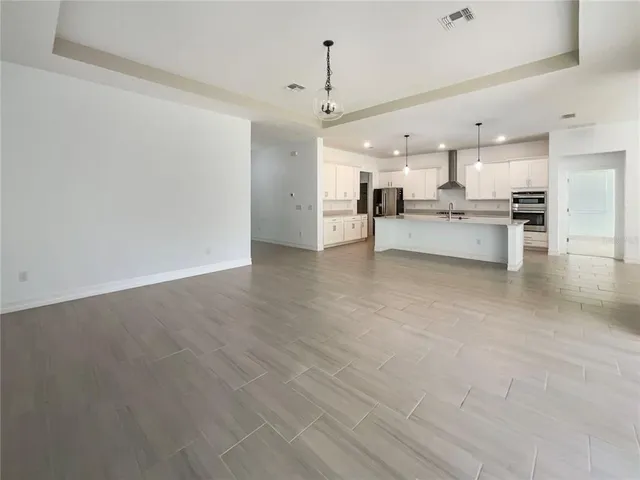 a view of kitchen with kitchen island stainless steel appliances refrigerator stove microwave and cabinets