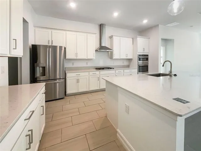 a kitchen with stainless steel appliances a refrigerator sink microwave and cabinets